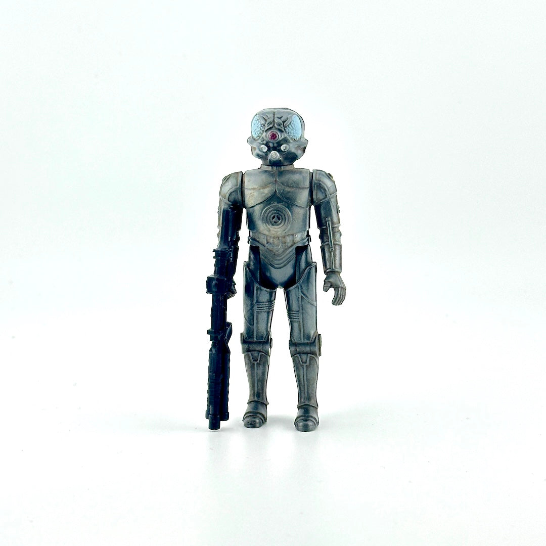 Action figure of gray cyborg holding big black gun against white background. 