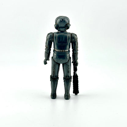 Action figure of gray cyborg holding big black gun against white background. 